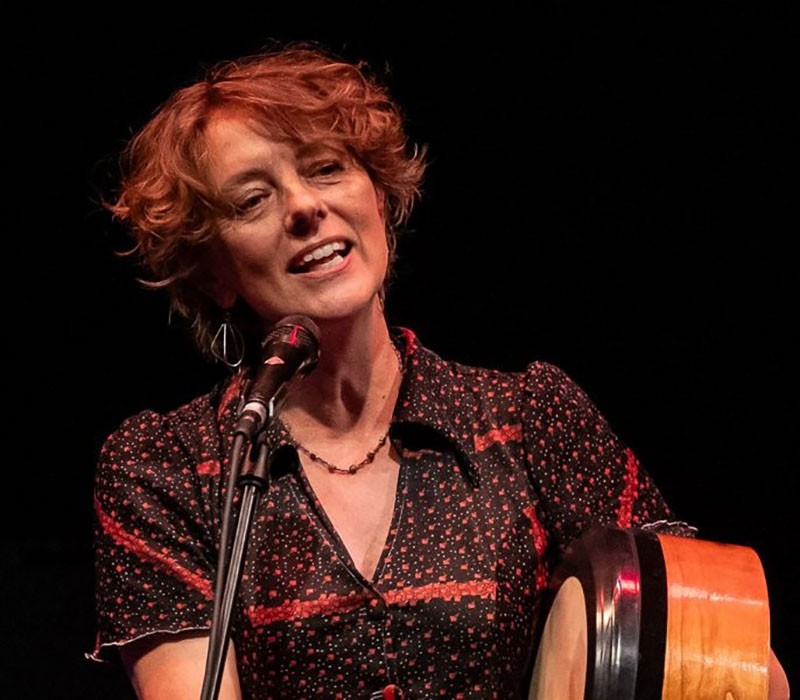 Margot Merah zingt tijdens een liveoptreden achter een microfoon
