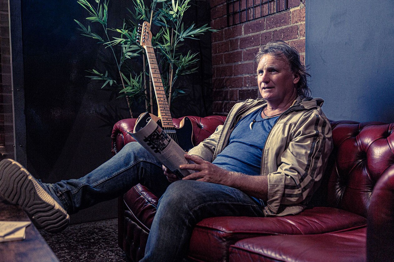 Mick McConnell with his guitar on the couch